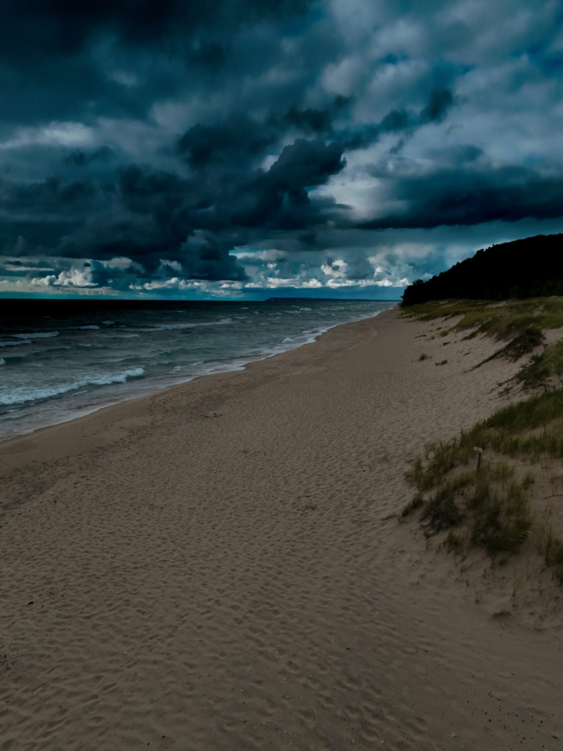 A sandy beach under a dark cloudy sky