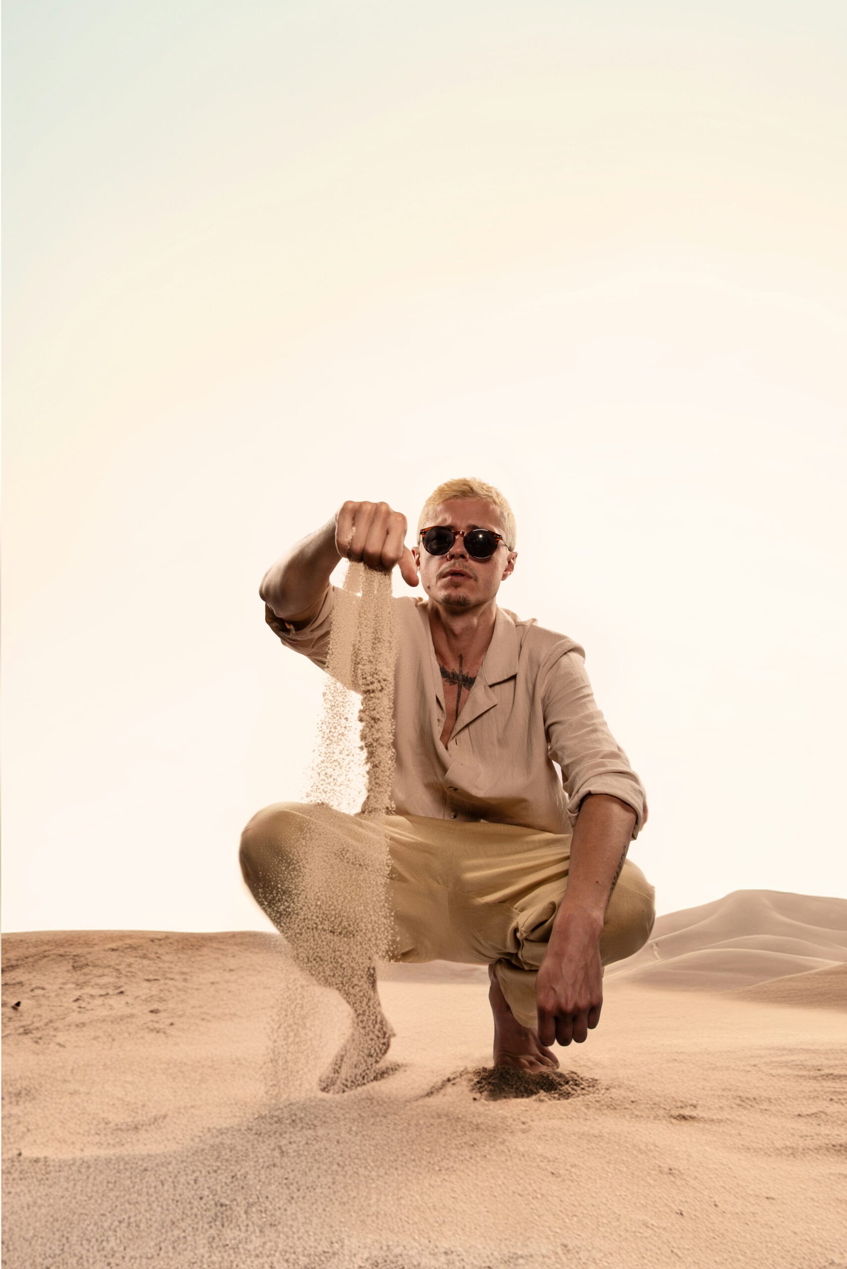 A man kneeling down in the middle of a desert