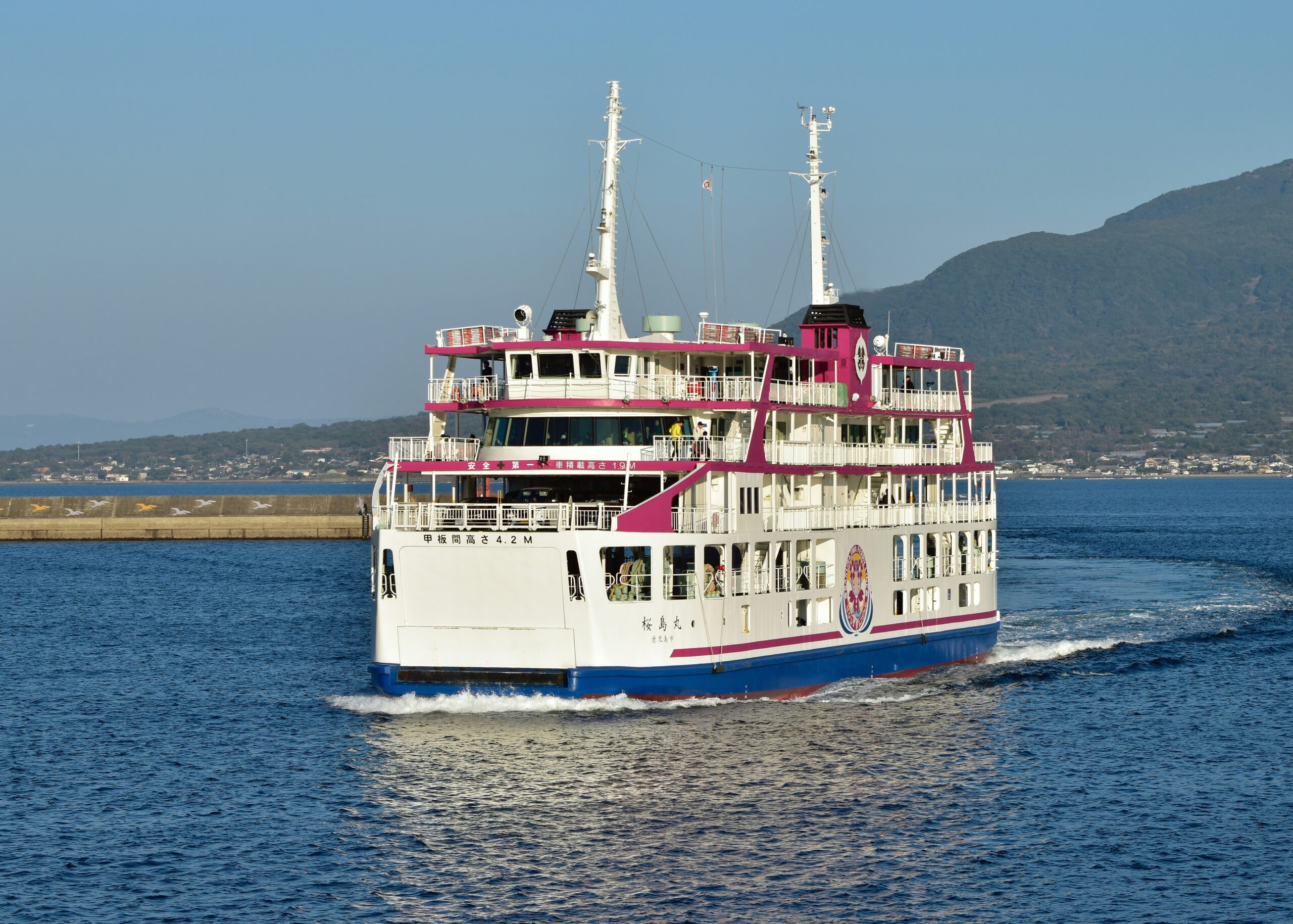 a large white and blue boat traveling across a body of water